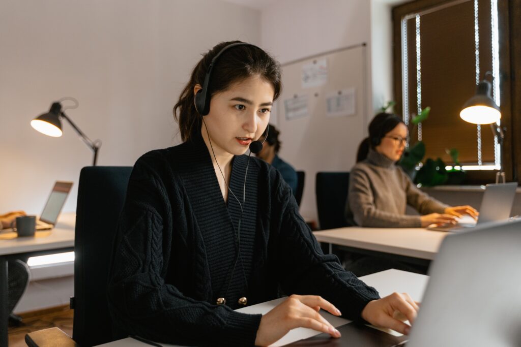 a person wearing a headset and using a laptop talking to a customer using Tech Jargons