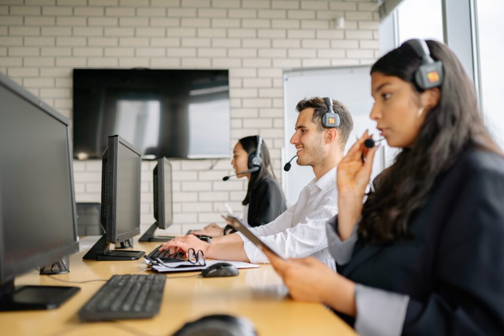 a group of people sitting at computers checking for Call center metrics