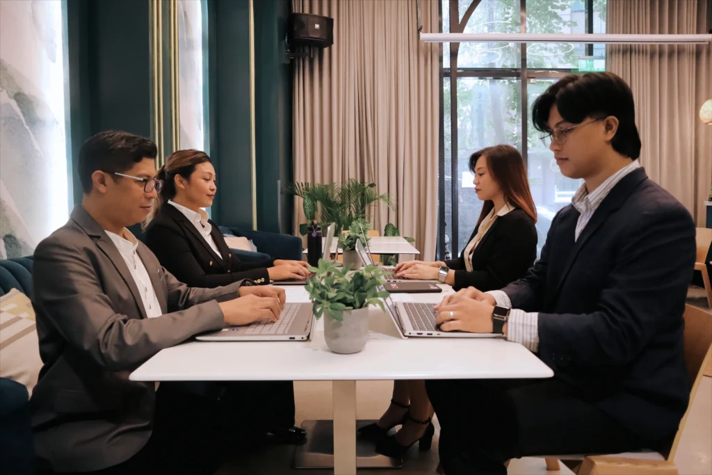 outsourced back office employees working table with laptops