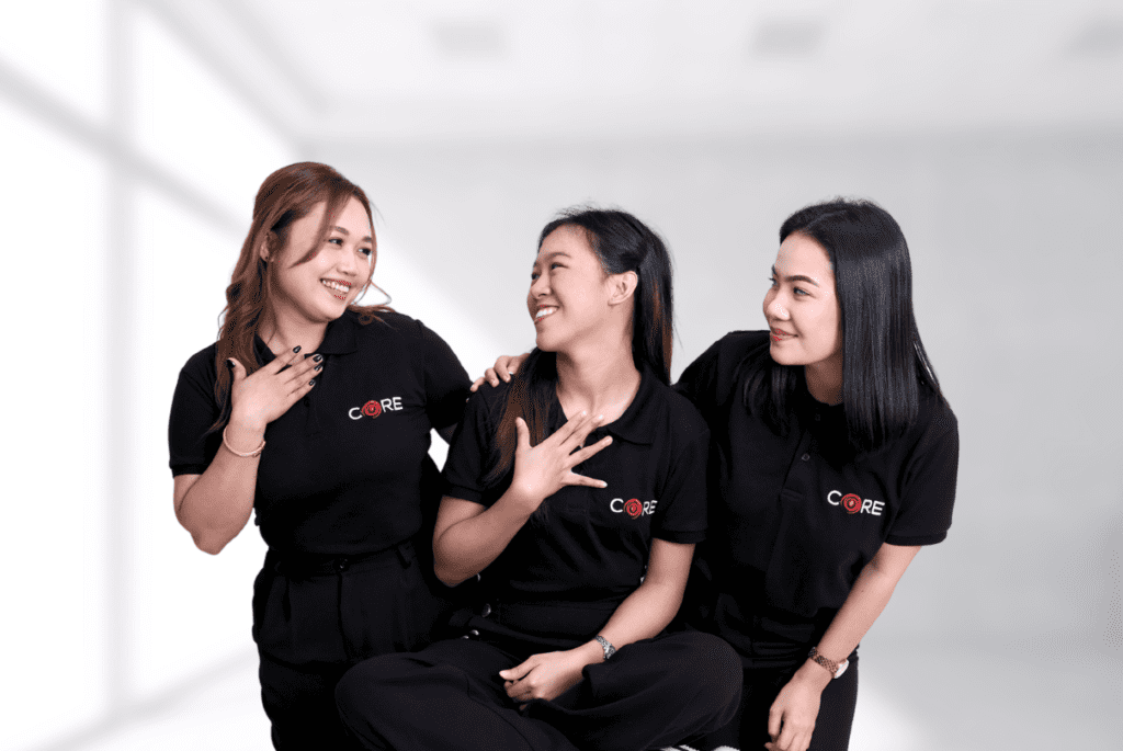 Three women in black shirts sitting on the floor during employee engagement programs.