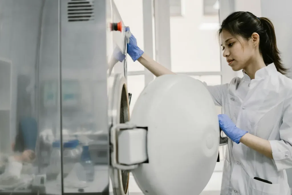 A woman in a lab coat holds a large white object, symbolizing the role of clinical trials in advancing healthcare.