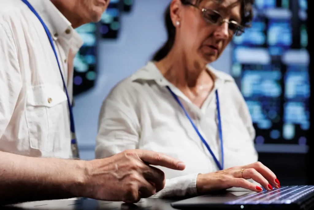 A man and woman collaborate on a computer, focusing on managed cybersecurity solutions for enhanced protection.