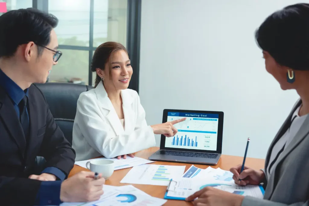 Asian businesswoman and man collaborating on a business plan in an office, focusing on outsourced finance and accounting strategies.