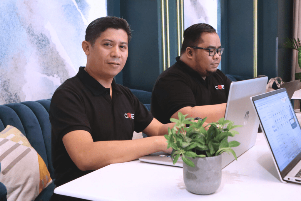 One CoreDev IT (CORE) male employees working with laptop for managed services