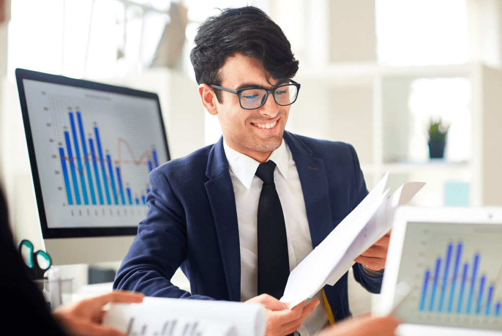 employee from accounting firm holding paper with screens with graph
