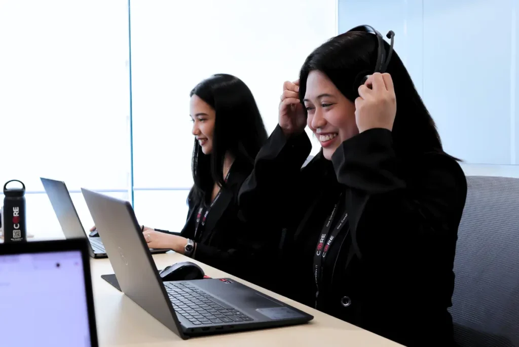 Two women collaborating at a desk, representing an Employer of Record in online education and global e-learning.