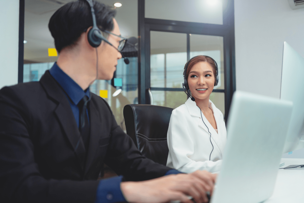 Asian businesswoman and man working together in a call center, representing customer service outsourcing in the Philippines.