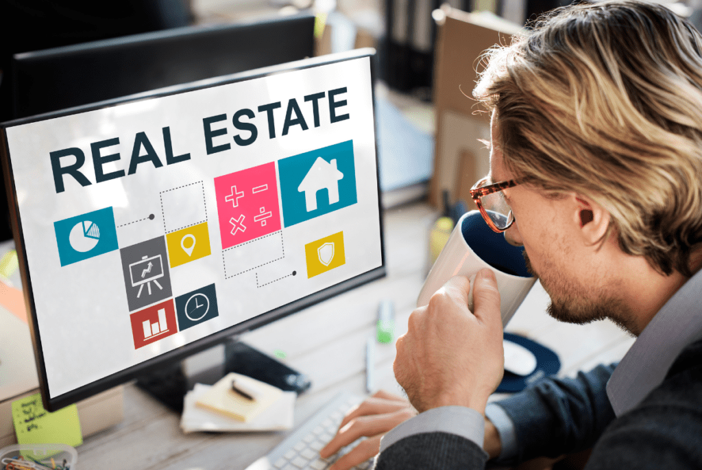 Man reviewing real estate listings on a computer screen, representing an employer of record in the property market.