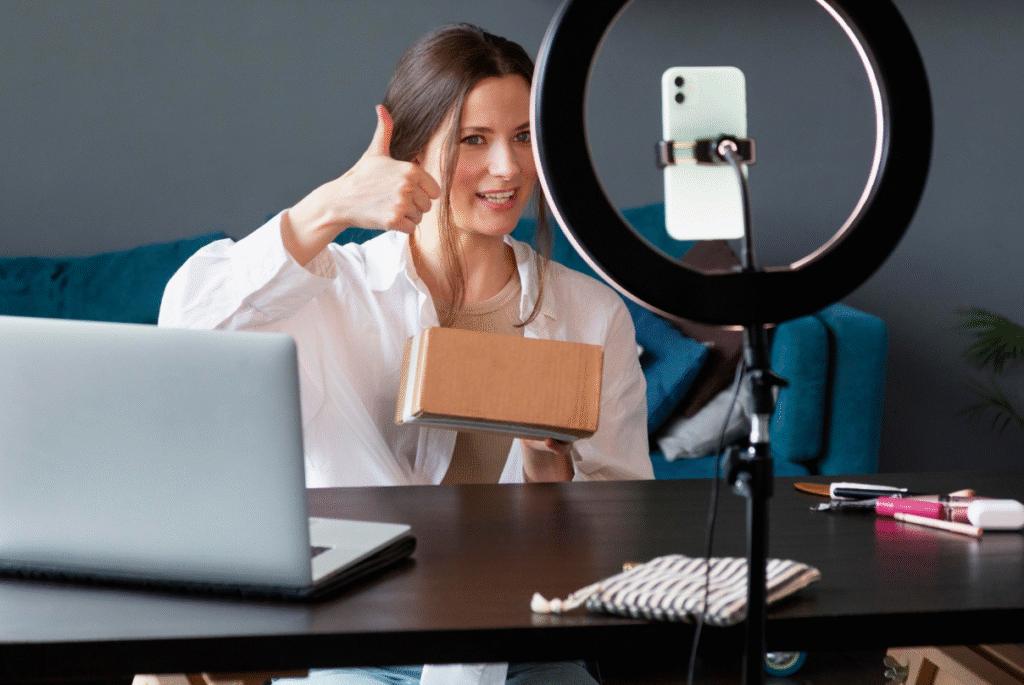 A woman holding a box and giving a thumbs up, symbolizing success in global influencer marketing.