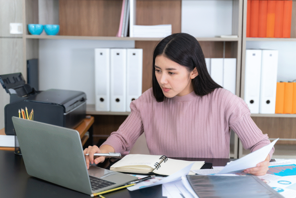 A woman working on her laptop in an office, focused on tasks related to admin managed services.
