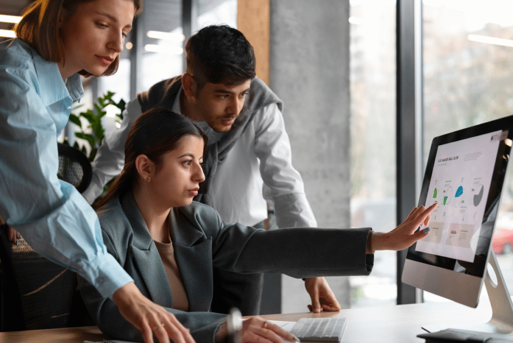Three colleagues collaborating on a computer in an office, emphasizing managed services and work-life balance.
