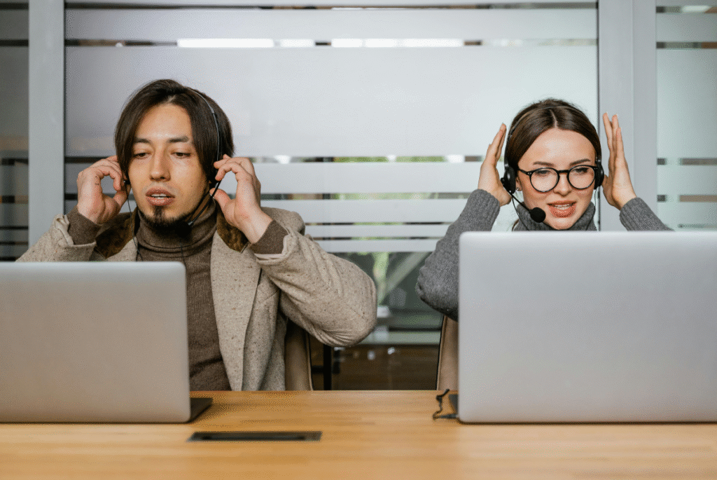 Two individuals wearing headphones sit at a desk, engaged in a discussion about cultural alignment offshore.