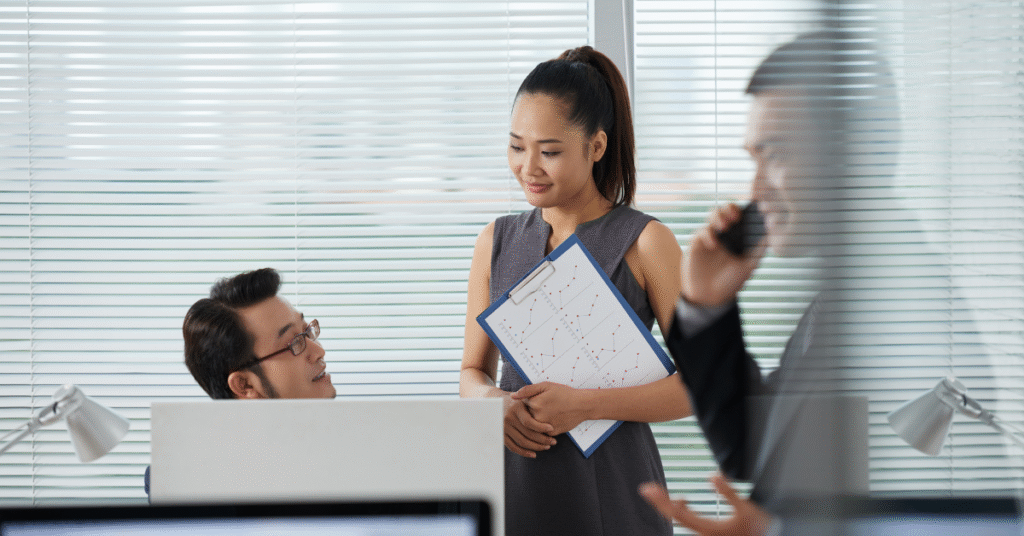 A woman discusses business process outsourcing with a man in an office setting.