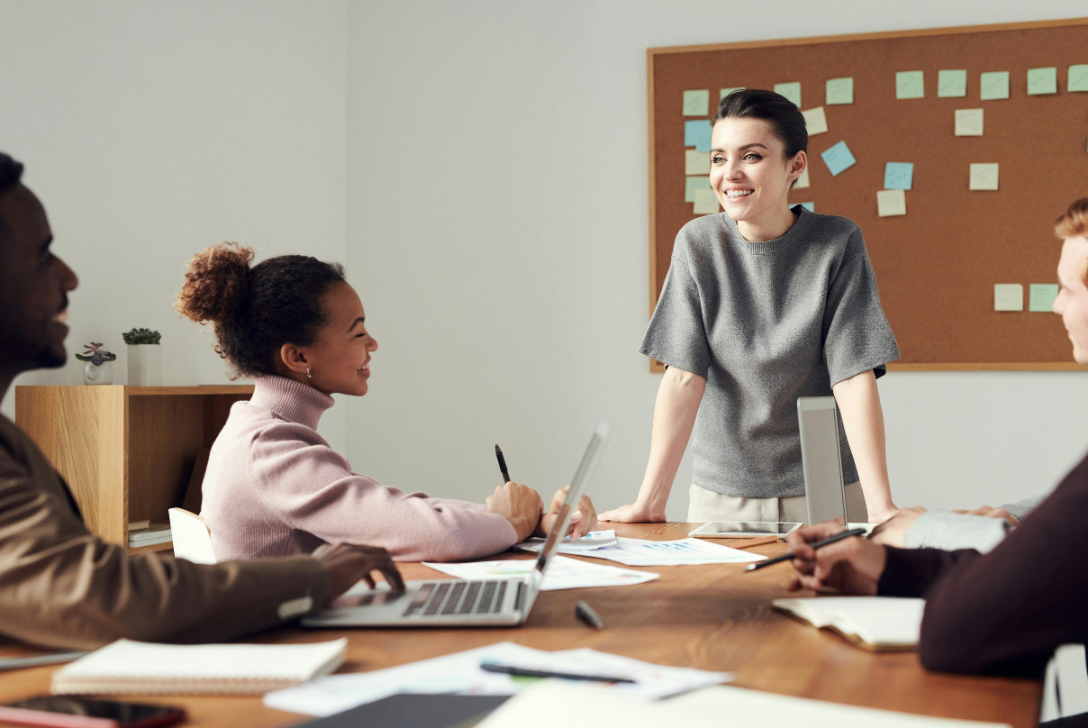 A woman stands before a group of people, discussing EOR companies and their services.