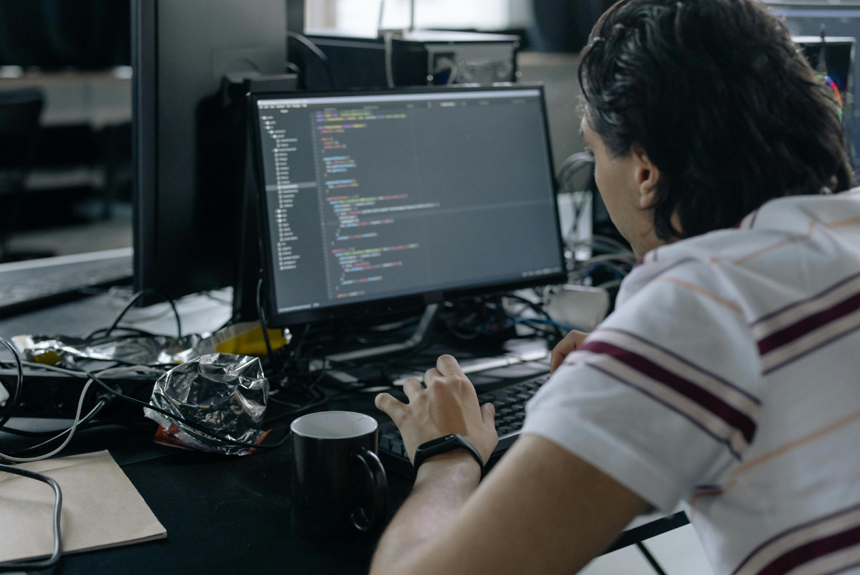 A man working on a computer with a keyboard at an offshore software development company.