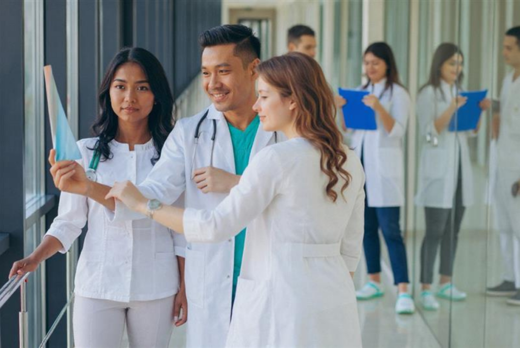 Doctors reviewing clinical trial data on a chart in a hospital corridor